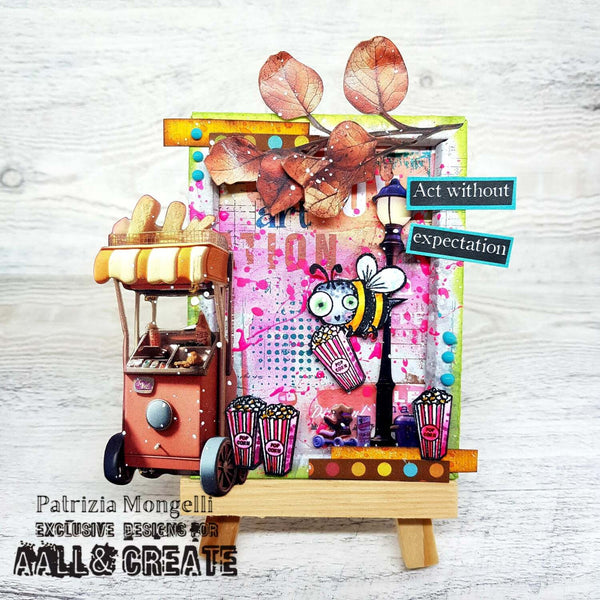 Colorful art piece with a hot dog cart, popcorn buckets, and decorative elements on a textured white background.