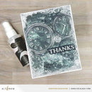 Card with clock design and 'THANKS' text, next to a spray bottle on a wooden surface.