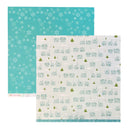Two Sides of patterned paper sheets from The Paper Aesthetic, featuring a teal sheet with white snowflakes and a cream sheet with a winter village pattern of houses and trees.