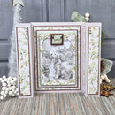 A handmade layered card featuring a central square panel with a black-and-white dog illustration and a small 'Happy Birthday' message, flanked by two vertical side panels with a light green floral pattern. The card is styled on a textured rug with holiday decorations in the background.