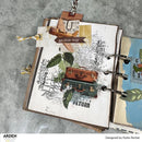 Open notebook with travel-themed collage on a textured surface, featuring images of suitcases and maps.