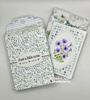Two handmade greeting cards with floral and polka dot patterns, displayed on a light gray background. One card features purple flowers and the other has a striped flap with a note that reads 'Just a little note'.