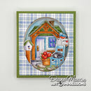 A square art card featuring a hand-painted illustration of a cozy cabin porch with a blue chair, red flowers, a birdhouse, and a cat, set against a blue and white plaid background with an olive green border. The card is signed by Diane Mason Art Impressions in the lower right corner.
