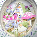 A circular collage of whimsical watercolor illustrations, including a small house, pink strawberries, purple flowers, a mushroom, a gnome, and a mailbox, arranged inside a round frame.