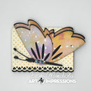 A handmade butterfly embellishment with layered pastel wings in lavender, peach, and yellow, mounted on a cream polka-dot card with black scalloped trim. The card is photographed on a light gray background with the text 'Dori Mendiola Art Impressions' printed below.