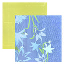 Two square patterned paper sheets overlapping on a white background. The top sheet is a solid pale yellow-green, and the bottom sheet has a blue floral print with white flowers, green stems, and white dots.