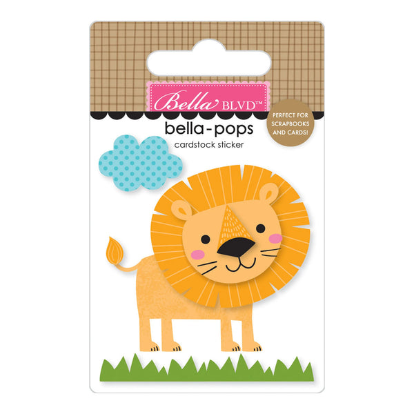 A Bella BLVD 'bella-pops' cardstock sticker featuring a cartoon lion with a yellow-orange mane, blue polka-dot cloud, and green grass on a white backing card.