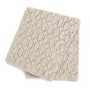 A folded cream-colored knit blanket with a textured openwork pattern, shown on a clean white background.
