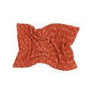 A textured, heathered rust-orange knit blanket or throw, styled in soft folds on a solid white background.