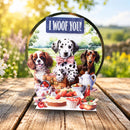 A circular pop-up greeting card featuring three dogs and a picnic scene, displayed on a wooden table outdoors. The card reads 'I WOOF YOU!' at the top.