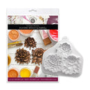 A silicone mould for sculpted peonies by Kathy Sue, shown with its retail packaging. The white silicone mold features three detailed embossed peony flower designs, positioned next to its printed packaging card which displays craft supplies and finished bronze-colored peony sculptures.