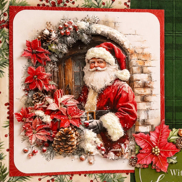 A square Christmas card featuring a festive 3D-style illustration of Santa Claus in a snowy arched doorway, surrounded by a wreath of red poinsettias, pinecones, berries, and snow. The card has a red border and is photographed on a decorative holiday-themed surface with green plaid and floral elements.