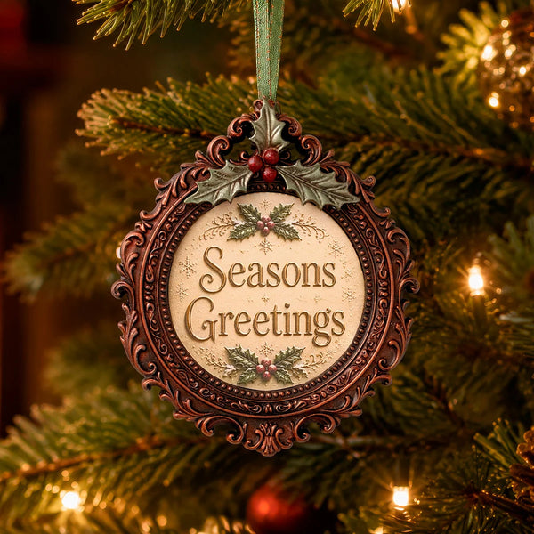 An ornate round Christmas ornament hanging on a lit Christmas tree. The ornament has a dark brown carved frame with holly and red berries at the top, and the words “Seasons Greetings” in brown lettering on a cream center panel.