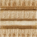 A close-up of a textured woven fabric or rug with horizontal bands of cream, tan, and light brown yarn, featuring ribbed and cable knit patterns.