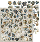 A sheet of vintage-style Christmas ornaments and decorative cutouts in muted blue, beige, and brown tones, arranged on a light gray background with a larger sample sheet overlapping a smaller sheet.