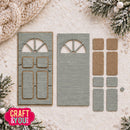 A flat-lay of a craft die-cut paper embellishment shaped like a rustic door, shown with its corresponding backing piece and individual cutout pieces on a textured cream background with holiday decorations.