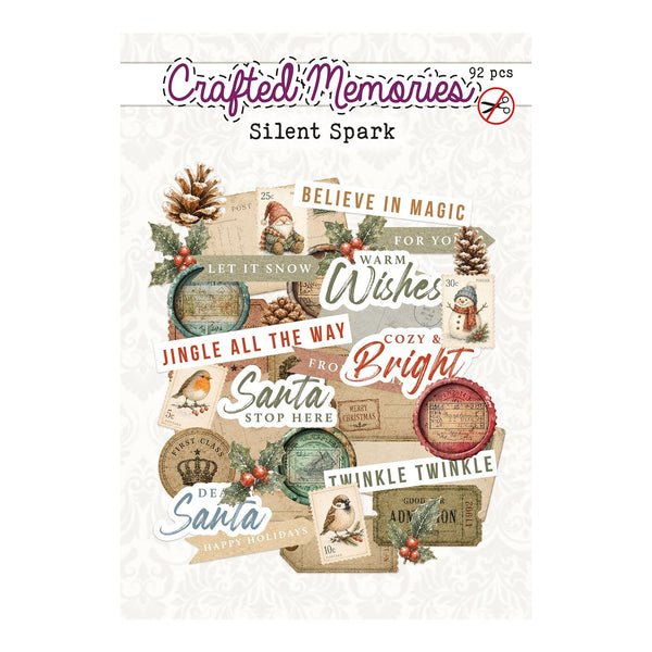 Crafted Memories 'Silent Spark' 92-piece scrapbook paper pack featuring a collage of vintage Christmas-themed labels, tags, pinecones, holly, and holiday text on a light cream patterned background.