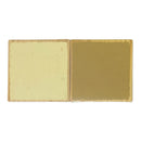 Two square Chipboard tiles shown side-by-side on a plain white background, displaying a matte cream-colored glaze on the left and a glossy ochre-gold glazed finish on the right.