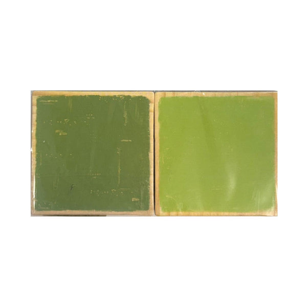 square green material samples side by side on a plain white background, one with a textured dark green surface and one with a smoother light green surface.
