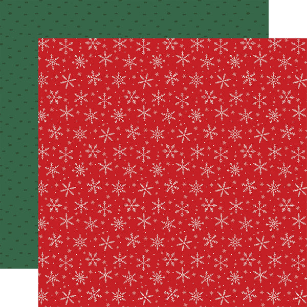 Two sheets of patterned paper shown flat against a white background, with one larger red sheet featuring white snowflakes and a smaller dark green sheet behind it with small dark motifs.