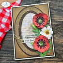 A handmade greeting card featuring layered oval frames, cursive script text, and three dimensional flowers including two red poppies, one white daisy, and green leaves. The card is displayed on a rustic wooden surface next to a red and white checkered cloth, with an 'Elizabeth craft designs' logo watermark in the top left corner.