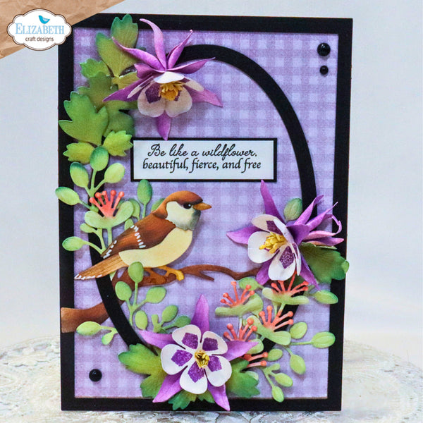 A handmade layered card featuring a bird, purple wildflowers, green leaves, and a black arch on a lavender gingham background, with a quote in the center. The card is framed in black and photographed against a light background.