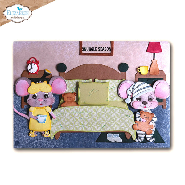 A 3D papercraft wall hanging featuring a cozy mouse bedroom scene with two cartoon mice, a bed, nightstand, lamp, and clock. The top sign reads 'SNUGGLE SEASON'.