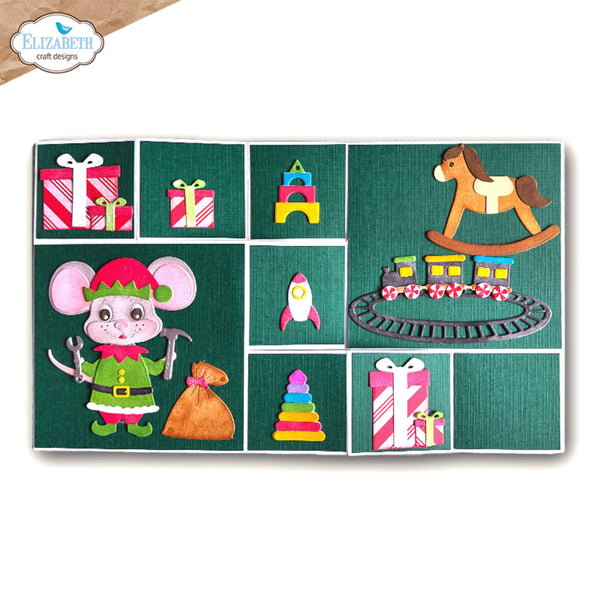 A square craft felt board featuring a Christmas-themed collage of felt pieces, including a mouse elf, gifts, a rocking horse, a toy train, and colorful toy shapes, all on a dark green textured background. The board is displayed on a clean white background with a brand logo in the top-left corner.