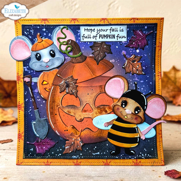 A handmade layered paper card featuring a smiling mouse in a bee costume next to a jack-o'-lantern, with autumn leaves and a starry night sky background. The card is signed by Elizabeth craft designs in the top left corner.
