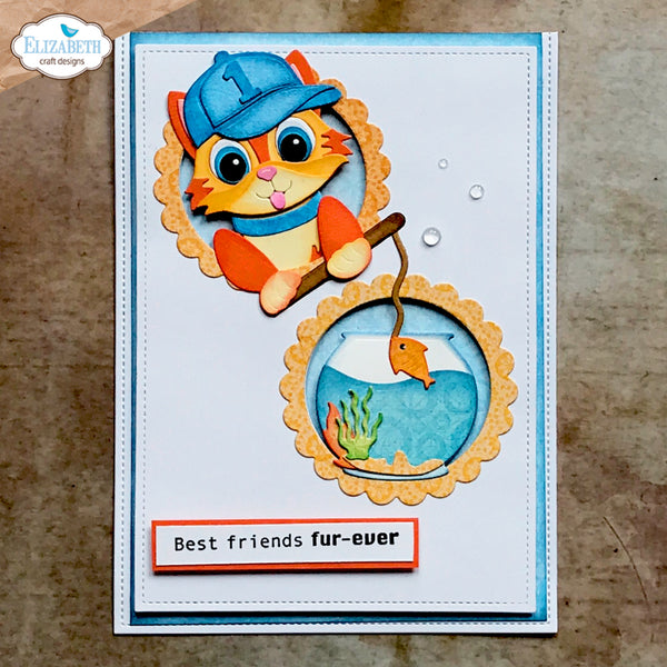 A handmade greeting card featuring a cartoon orange cat wearing a blue fisherman hat and holding a fishing rod over a fishbowl illustration. The card has a blue border, a white center, a small message tab reading 'Best friends fur-ever', and is photographed on a textured brown surface.