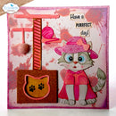 A handmade greeting card or art print featuring a cute 3D cat character wearing a pink hat and cape, next to a pink cat tree and a glittery brown cat-shaped ornament. The card has a pink and white splattered background with the text 'Have a PURRfect day!' and a visible 'Elizabeth craft designs' logo in the top left corner.