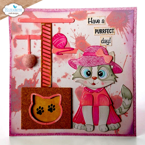 A handmade greeting card or art print featuring a cute 3D cat character wearing a pink hat and cape, next to a pink cat tree and a glittery brown cat-shaped ornament. The card has a pink and white splattered background with the text 'Have a PURRfect day!' and a visible 'Elizabeth craft designs' logo in the top left corner.