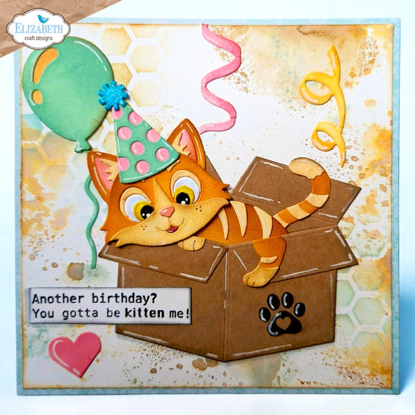 A square handmade greeting card featuring a cartoon orange kitten wearing a pink and green party hat and peeking out of a brown box. The card includes a green balloon, pink and yellow streamers, a pink heart, and the text 'Another birthday? You gotta be kitten me!'.