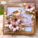 A square handmade greeting card featuring a small bird perched among layered pink and beige flowers with green leaves, set in a decorative gold-toned frame. A ribbon banner reads, 'we've simply, bloom wildy.