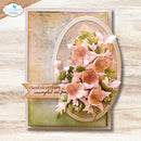 A handmade greeting card featuring a 3D floral design with pink and peach flowers, green leaves, and a banner that reads 'Cherish the wildflowers, unscripted and free'. The card is displayed on a light wood background with an 'Elizabeth craft designs' logo in the top left corner.
