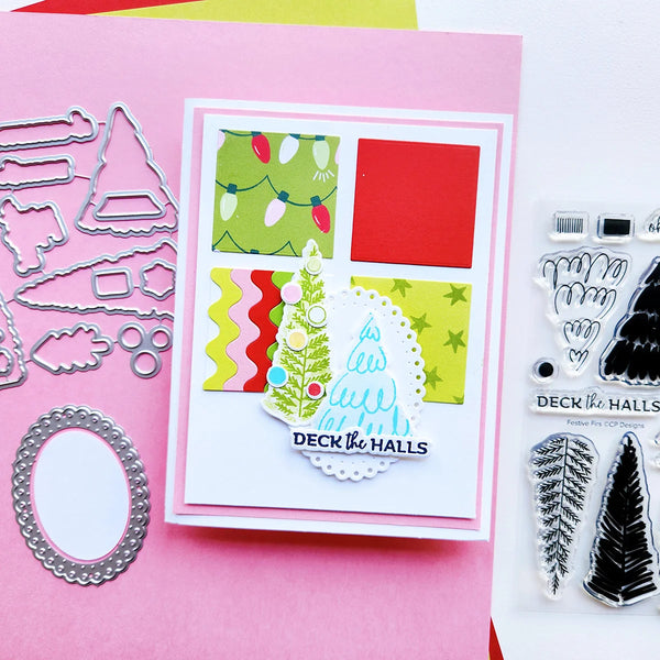 A handmade Christmas card with layered white borders, colorful patterned paper sections, and a die-cut tree design stamped with the words 'DECK THE HALLS', shown alongside metal die-cutting templates on pink cardstock and clear stamp blocks on a white background.