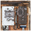 A styled flat-lay of vintage metal craft embellishments and tools on an old newspaper background. The set includes a white embossed floral mold with a silver frame design, a dark rusted metal ornament piece, ornate silver filigree cutouts, scissors, and other antique hardware.