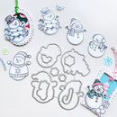 A set of metal die-cut crafting templates featuring cartoon snowman designs, displayed on a white background alongside decorated paper tags and small snowflake embellishments.