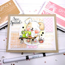 A handmade greeting card featuring a cute puppy sewing with a green sewing machine, styled on a kraft card base with layered patterned paper. The card is displayed on a white surface with crafting tools and Gina K.