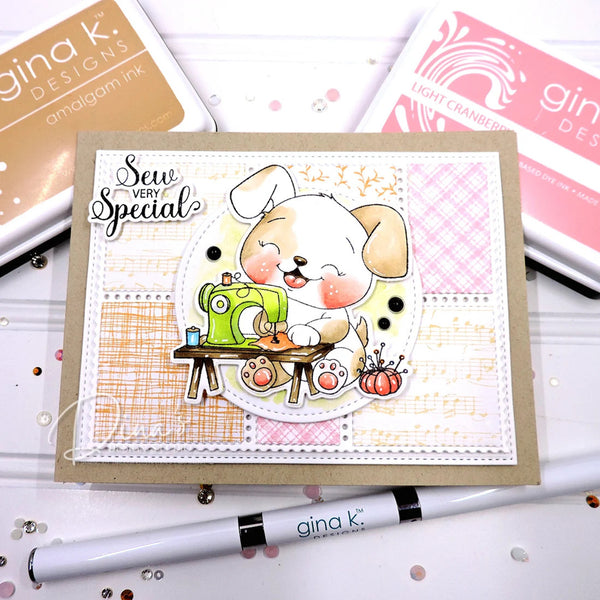 A handmade greeting card featuring a cute puppy sewing with a green sewing machine, styled on a kraft card base with layered patterned paper. The card is displayed on a white surface with crafting tools and Gina K.