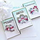 Three handmade holiday greeting cards with penguin illustrations, arranged on a white surface with white flowers in the corner. The cards feature layered white and mint green backgrounds, black borders, and text including 'Wishing you a sleigh full of happiness' and 'Fa la la la love sharing the joy'.
