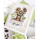 A handmade greeting card featuring a stamped sunflower arrangement in a pot with the words 'GRATEFUL for you' on a textured cream background, styled with green envelopes and stamp blocks.