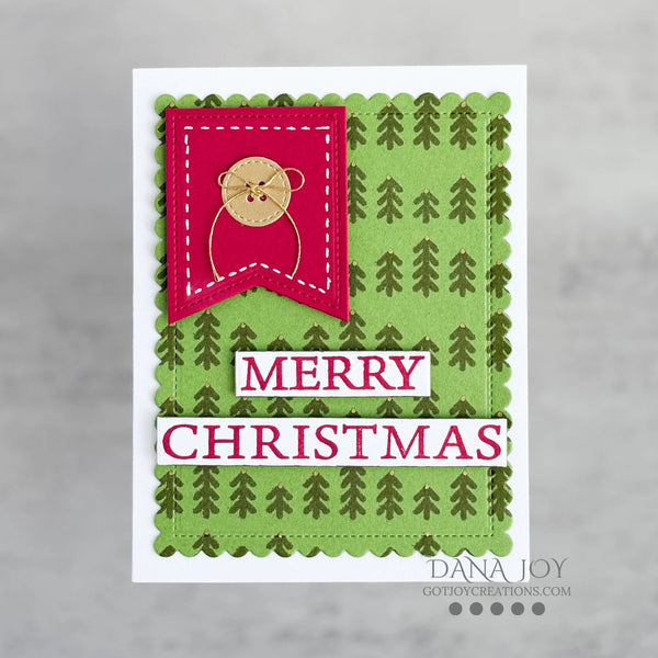 A handmade Christmas greeting card featuring a green patterned background with pine tree motifs, a bright pink banner with a teddy bear illustration, and white lettering that reads 'MERRY CHRISTMAS'.