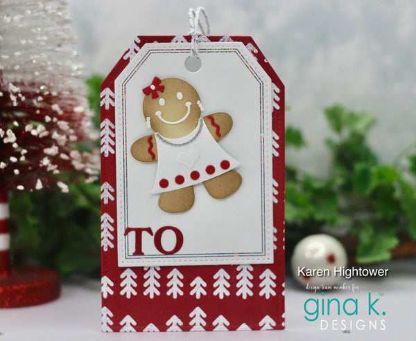 A handmade Christmas greeting card tag featuring a gingerbread man figure in a white dress with red polka dots, set against a red and white patterned border. The tag is decorated with the word 'TO' in red and is shown with holiday decorations in the background.