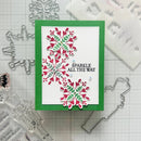 A handmade holiday card featuring three layered die-cut snowflakes in red and green on a white background with a green border. The card has the text 'SPARKLE ALL THE WAY' in black.
