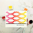 Colorful geometric patterned card with 'gina k.' stamps on a marble surface