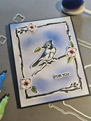Handmade card with a bird illustration and 'For You' text on a gray surface.