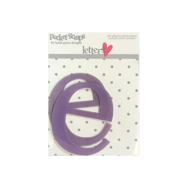 A purple self-adhesive plastic letter 'e' from the 'Pocket Scrap' collection by Heidi Grace Designs, shown inside its original retail packaging with a white polka-dot background.