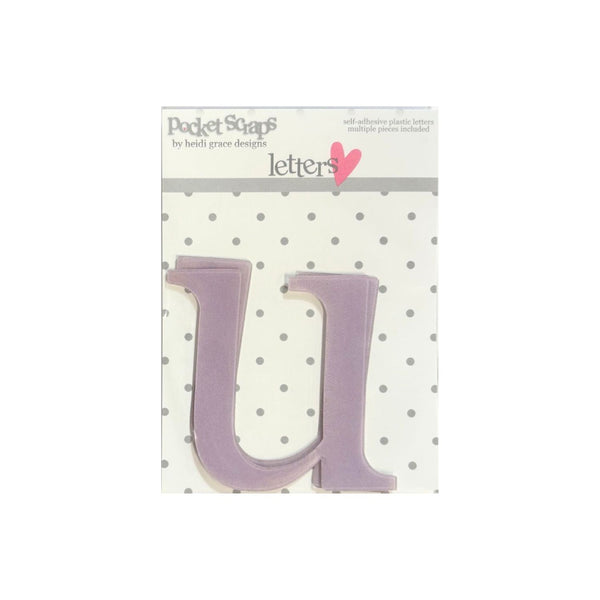 A lavender purple plastic letter 'U' from the brand Pocket Scapes, displayed on its original white and gray polka dot backing card.