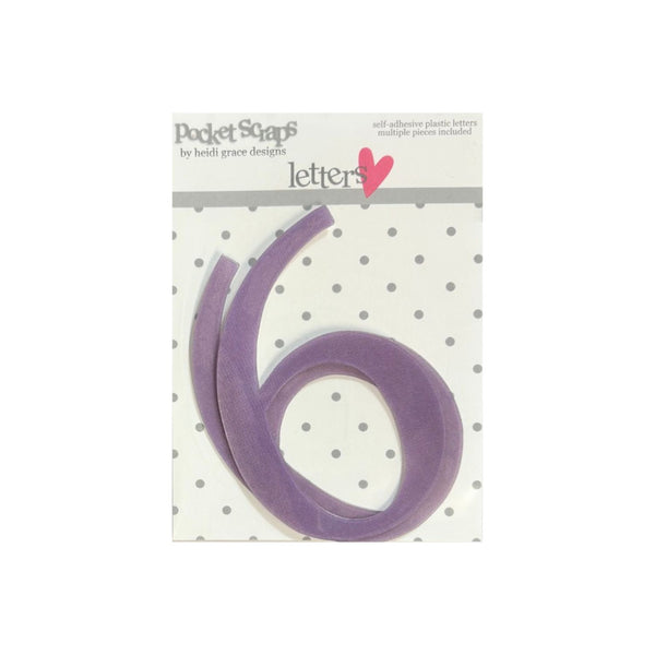 A purple plastic number 'six' from Pocket Scaps by Heidi Grace Designs, shown in its original retail packaging against a white background.